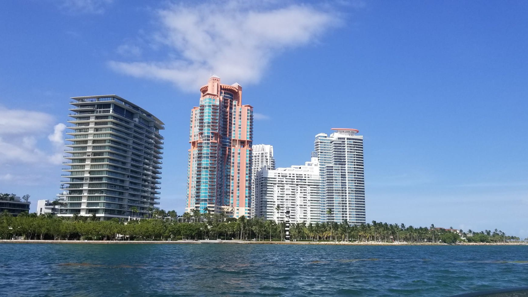 Torres de condomínio residencial na ponta sul de Miami Beach vistas do mar, com palmeiras na orla e céu azul