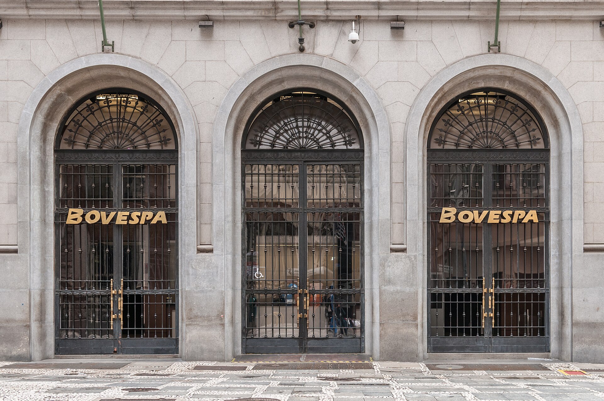 Fachada do prédio-sede da bolsa no centro de São Paulo, com três portões em arco de ferro e o letreiro Bovespa em dourado